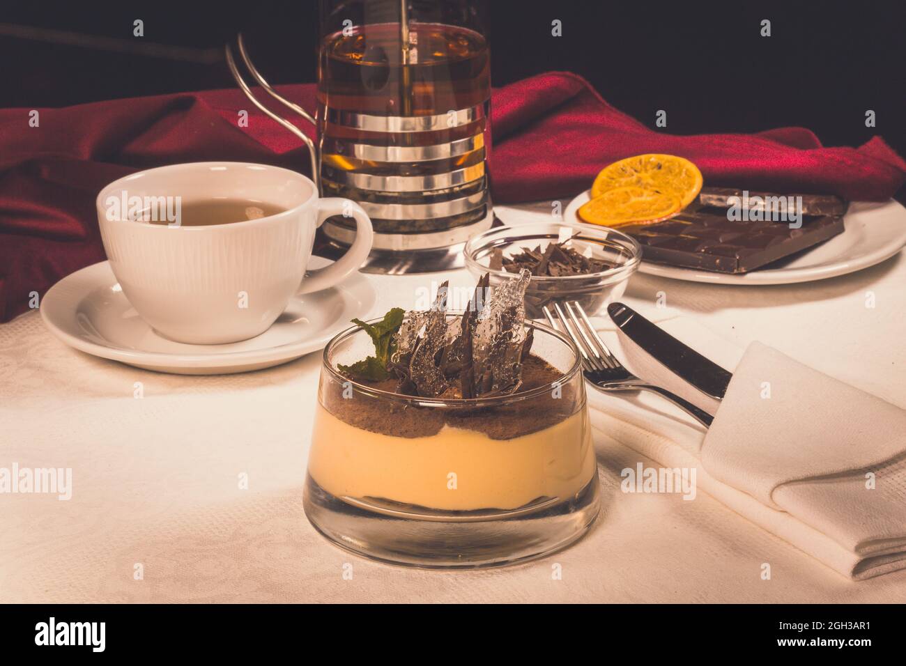 Dessert tiramisù con cioccolato e tè. Torta nella composizione Foto Stock