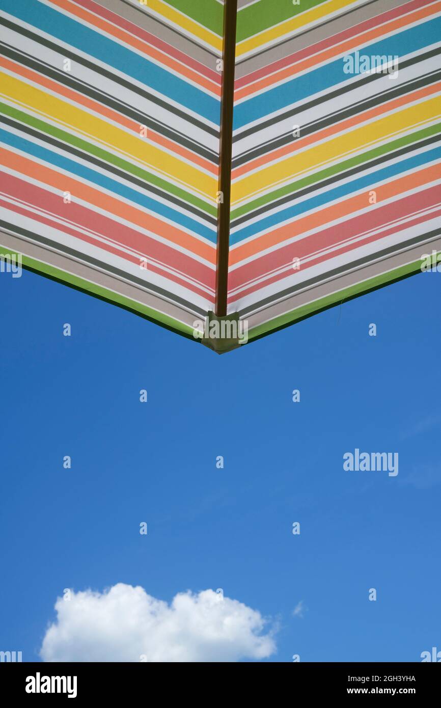 Ombrello colorato contro il cielo blu chiaro il giorno d'estate Foto Stock