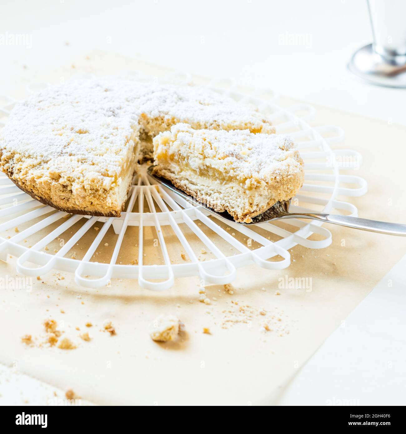 sminuzzare la mela con lo zucchero a velo, servito su una griglia di torta bianca Foto Stock