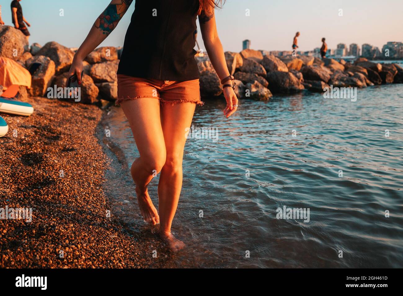 Una donna con un piede club gradini sulla riva del mare. Gambe vicine. Il concetto di clubfoot e artrite. Foto Stock