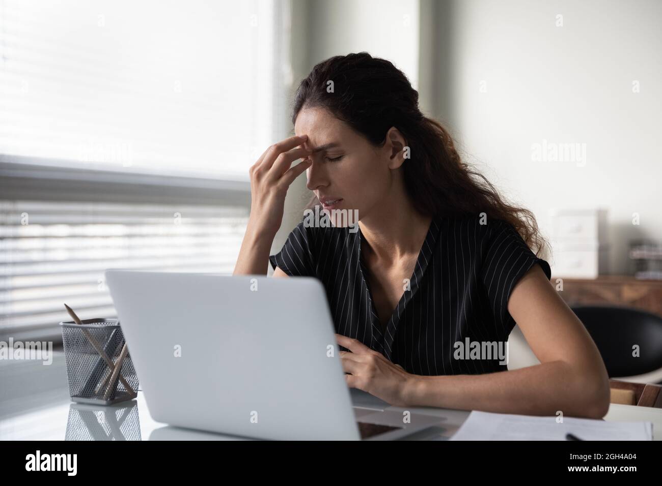 Triste frustrata donna millenaria stanca di lavoro al computer Foto Stock