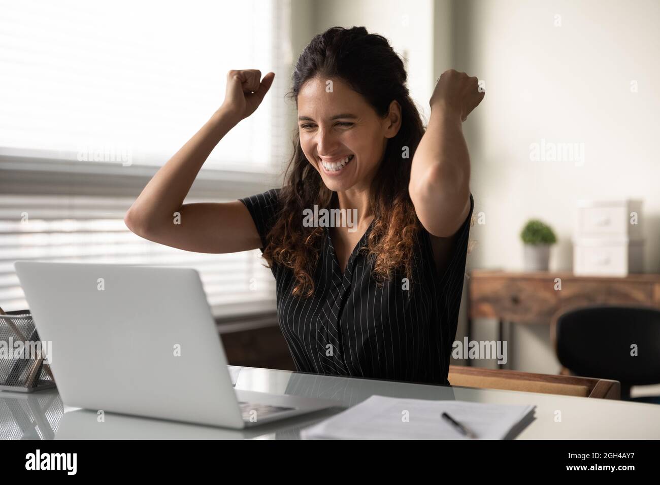 Felice eccitato donna d'affari millennial in casual eccitato con buone notizie Foto Stock