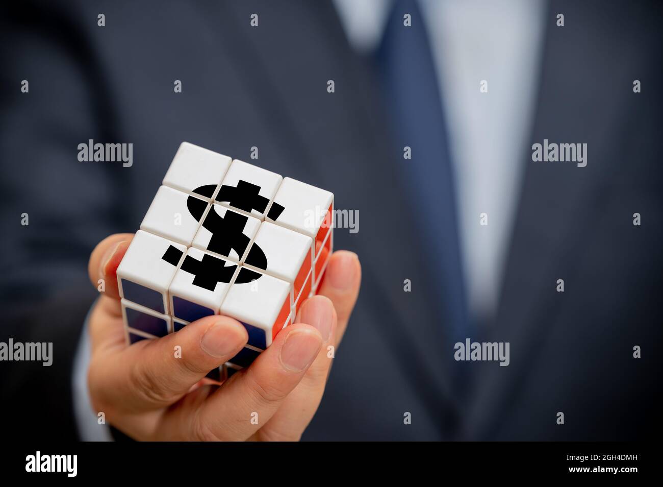 Mani di un uomo d'affari che tiene un cubo con un'icona di indicazione del dollaro visibile. Foto Stock Mani di un uomo d'affari che tiene un cubo con un'icona di indicazione del dollaro visibile. Foto Stock