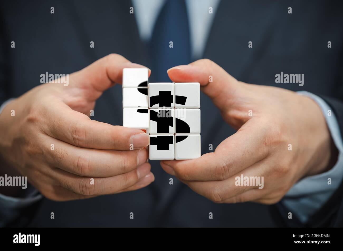 Mani di un uomo d'affari che tiene un cubo con un'icona di indicazione del dollaro visibile. Foto Stock Mani di un uomo d'affari che tiene un cubo con un'icona di indicazione del dollaro visibile. Foto Stock