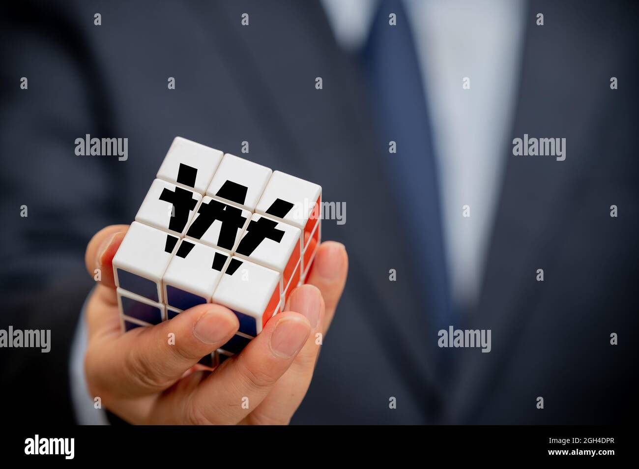 Le mani di un uomo d'affari che tiene un cubo con un'icona di indicazione di vittoria coreana visibile. Foto Stock Le mani di un uomo d'affari che tiene un cubo con un'icona di indicazione di vittoria coreana visibile. Foto Stock