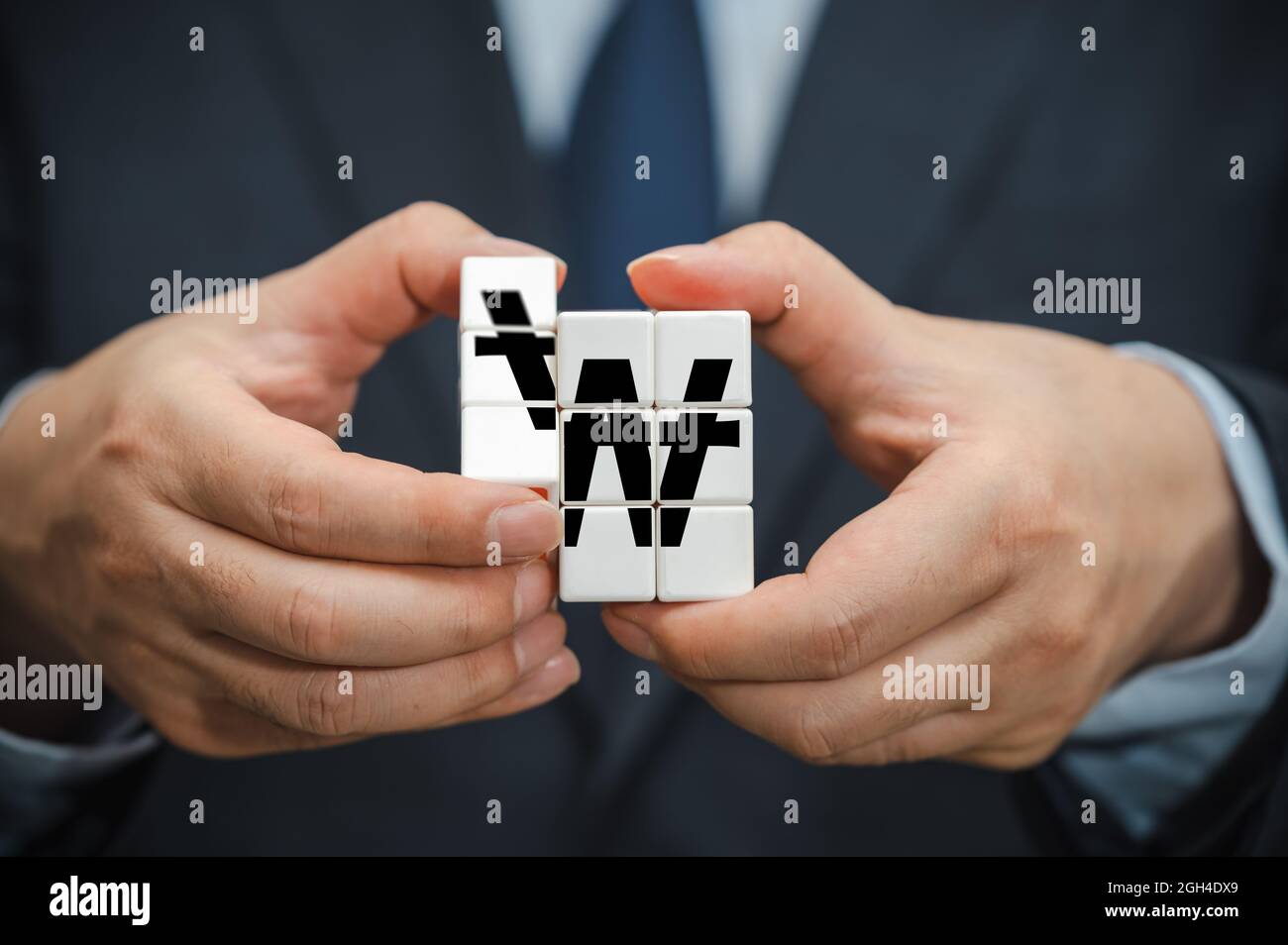 Le mani di un uomo d'affari che tiene un cubo con un'icona di indicazione di vittoria coreana visibile. Foto Stock Le mani di un uomo d'affari che tiene un cubo con un'icona di indicazione di vittoria coreana visibile. Foto Stock