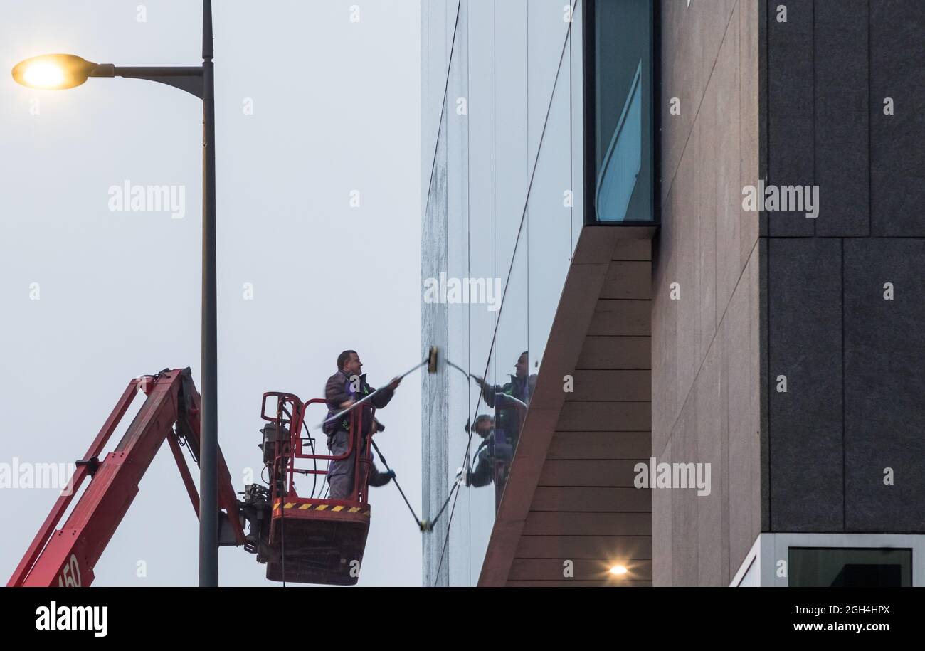 Cork City, Cork, Irlanda. 05 settembre 2021. Robert Healey e Cormac Higgins puliscono le finestre utilizzando un braccio telescopico sugli uffici di One Albert Quay in una mattinata umida e nebulosa a Cork City, Cork, Irlanda. - immagine; David Creedon Foto Stock