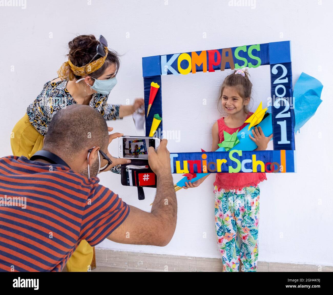 I genitori fotografano la ragazza che riceve il cono della scuola tedesca tradizionale il primo giorno della scuola, la scuola internazionale di Kompass, il Cairo, Egitto Foto Stock