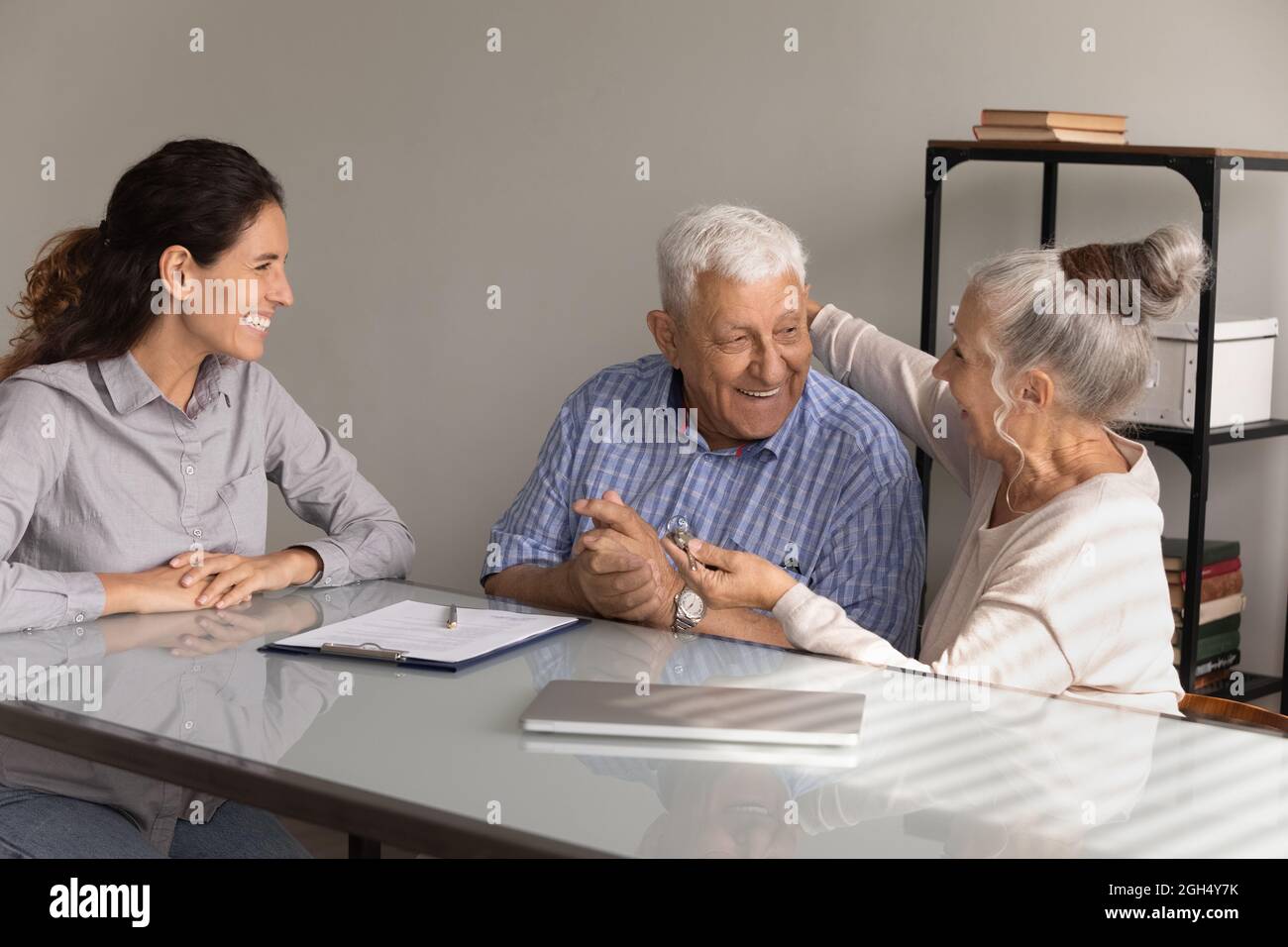 Felice anziano marito e moglie che tengono la chiave, abbraccio Foto Stock