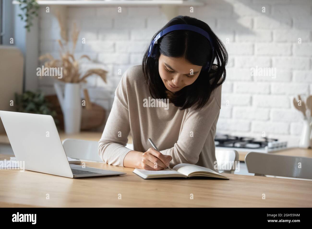 Sorridendo bella giovane donna asiatica che ascolta lezione educativa. Foto Stock