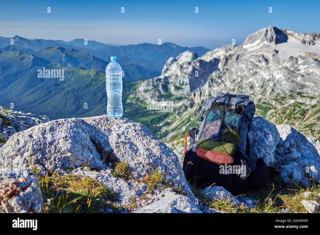 Una bottiglia d'acqua e uno zaino sulla cima della montagna Foto Stock