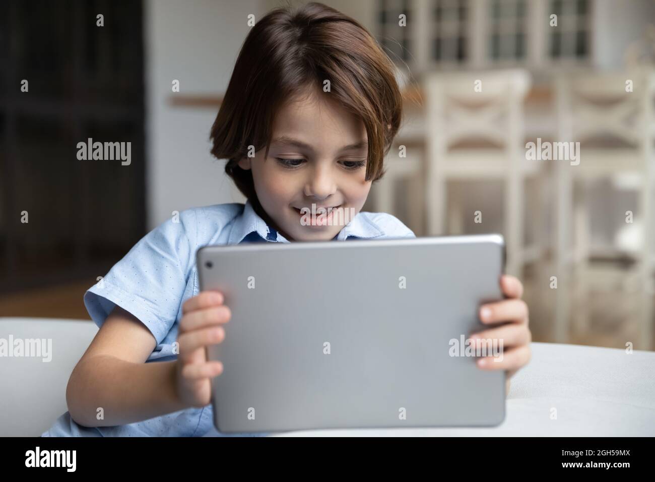 Felice piccolo ragazzo carino ragazzo usando il tablet digitale del computer. Foto Stock