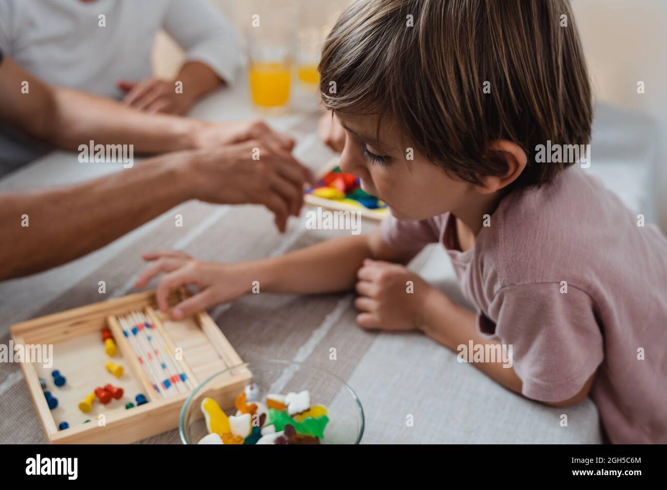Famiglia felice divertirsi giocando a giochi da tavolo con i bambini insieme a casa - Focus su bambino ragazzo Foto Stock