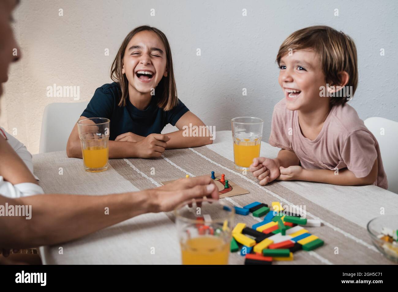 Felice famiglia ispanica divertirsi giocando giochi da tavolo con i bambini insieme a casa - Focus on girl face Foto Stock