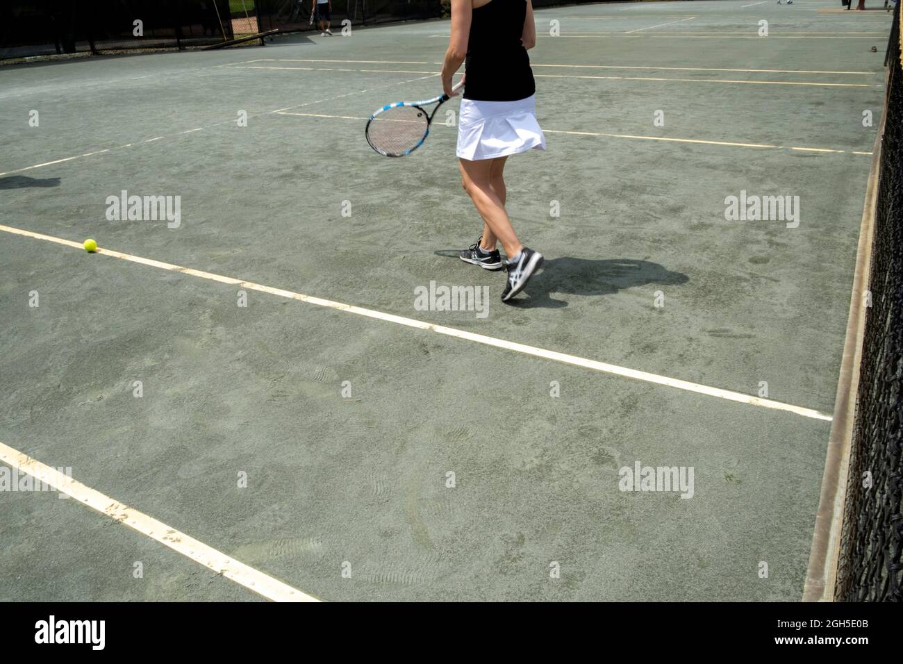 Donna sul campo da tennis durante una partita di tennis Foto Stock