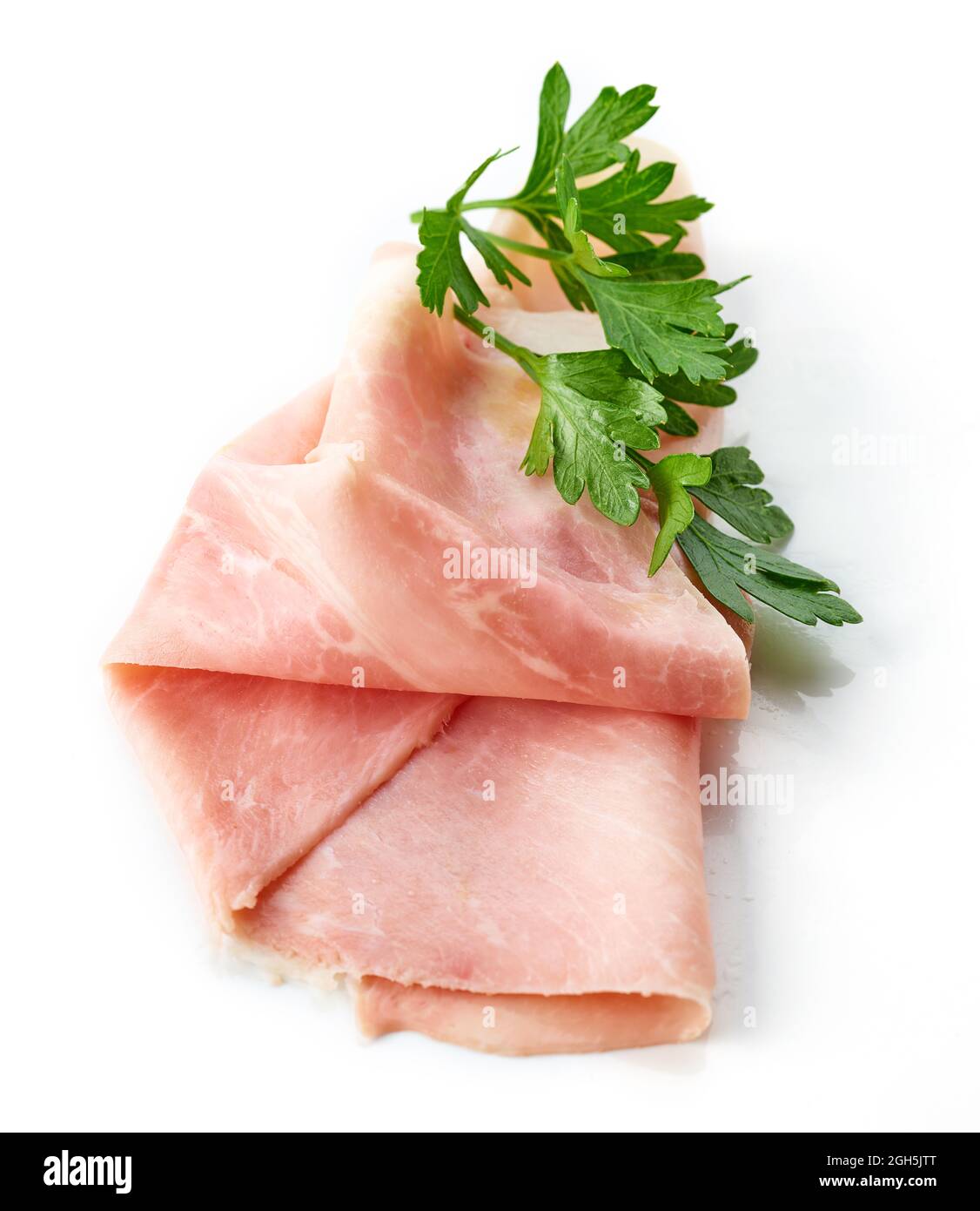 Fette di prosciutto e foglia di prezzemolo isolato su sfondo bianco, vista dall'alto Foto Stock