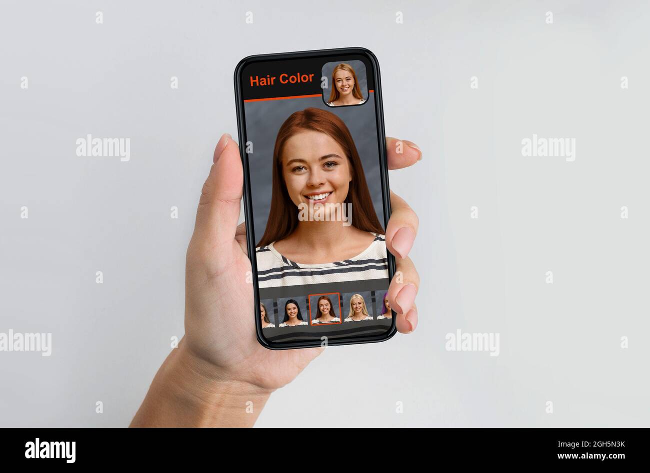 Donna bionda che usa il software di simulazione del colore dei capelli sul telefono cellulare Foto Stock