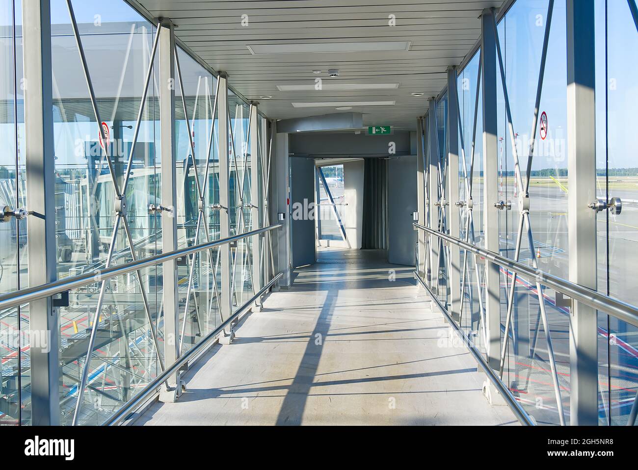 Ponte di imbarco passeggeri PBB per salire a bordo dell'aeroplano. Ingresso alla stazione ferroviaria tramite il ponte sospeso Foto Stock