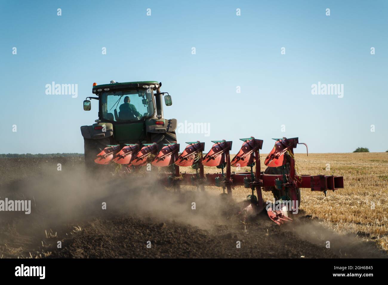 Il trattore aratura il terreno. Immagine agricola Foto Stock