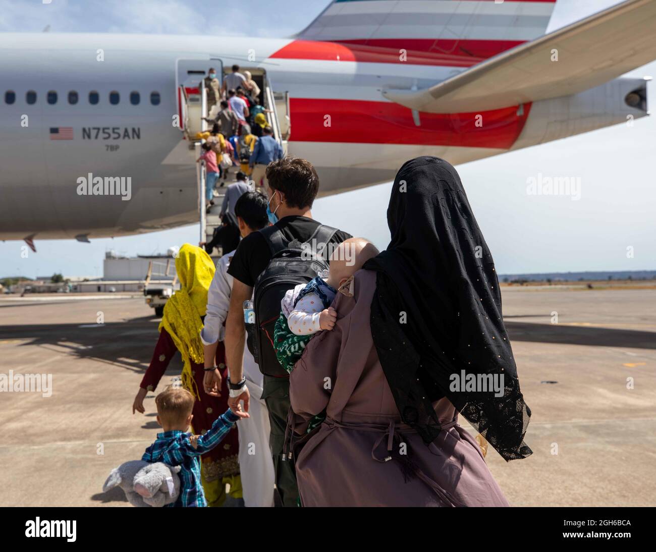 210904-N-CJ510-0152 STAZIONE AERONAVALE DI SIGONELLA, ITALIA (SETTEMBRE 4, 2021) – gli evacuati dall'Afghanistan salono a bordo di un Boeing 777 con partenza dalla Stazione aeronavale (NAS) di Sigonella, 4 settembre 2021. NAS Sigonella sostiene la missione del Dipartimento di Stato per facilitare il trasferimento sicuro dei cittadini statunitensi, dei beneficiari di visti speciali per l'immigrazione e delle popolazioni vulnerabili provenienti dall'Afghanistan. (STATI UNITI Navy Photo by Mass Communication Specialist 2a Classe Andrea Rumple) Foto Stock