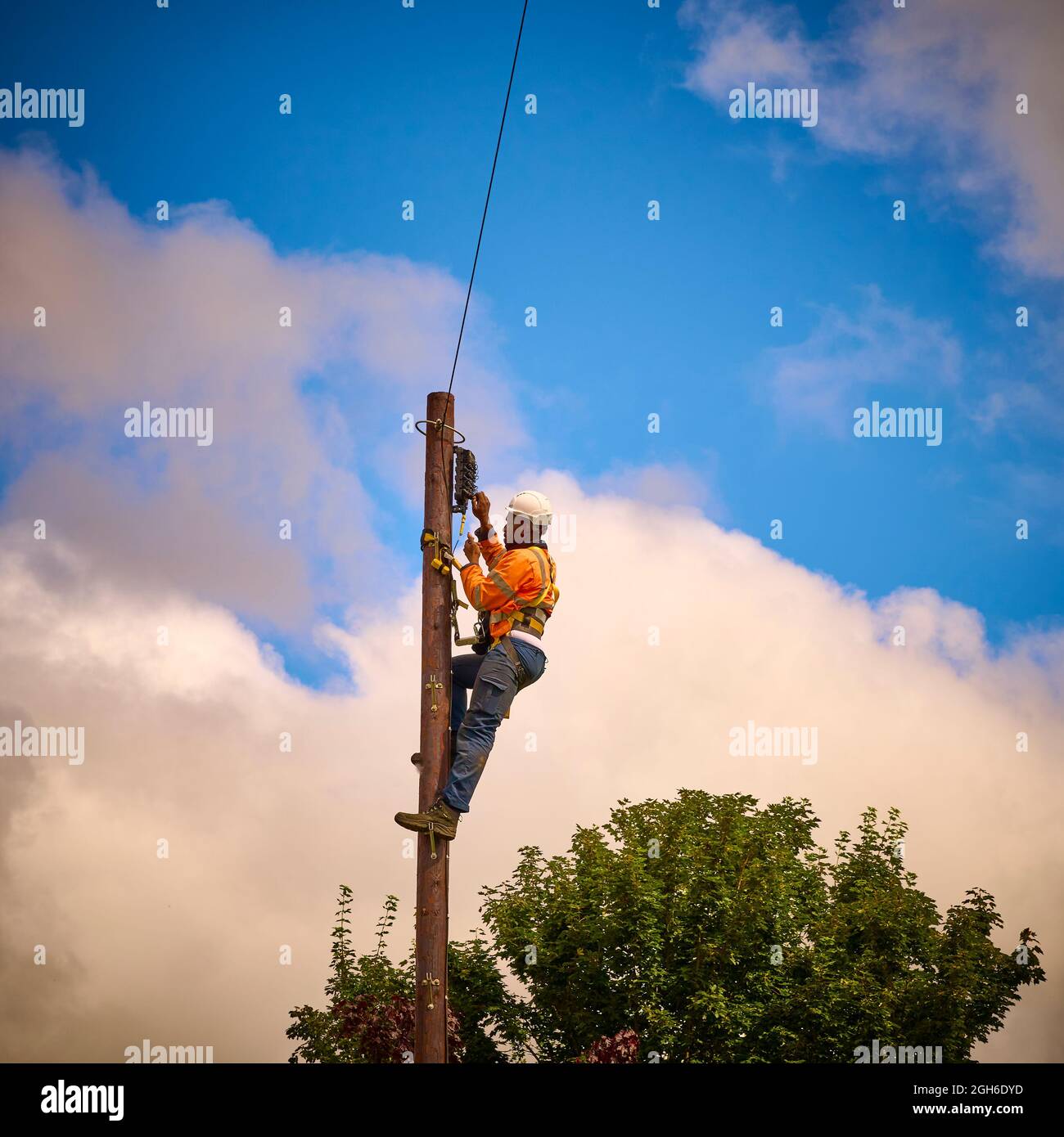 Ingegnere telefonico che lavora un palo telegrafico Foto Stock