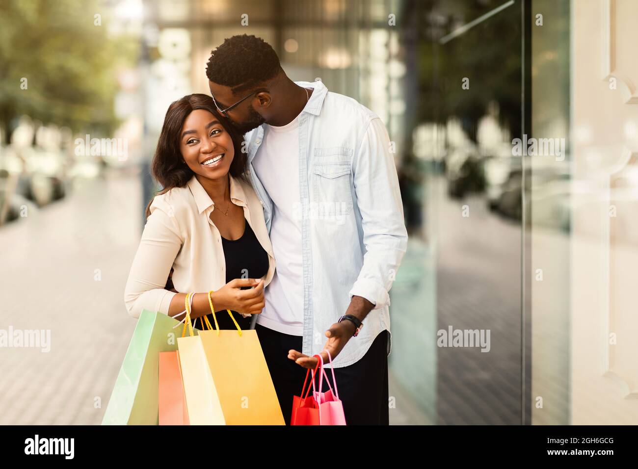 Ritratto di coppia nera con shopping borse baciare Foto Stock