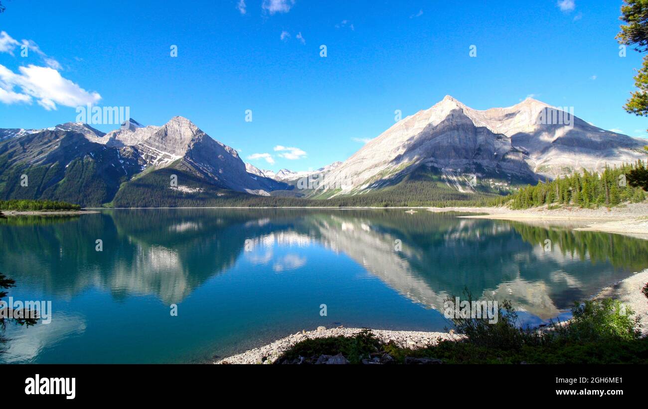 Bellissimo lago con cielo limpido e acqua riflettente. Montagne rocciose, Canada Foto Stock