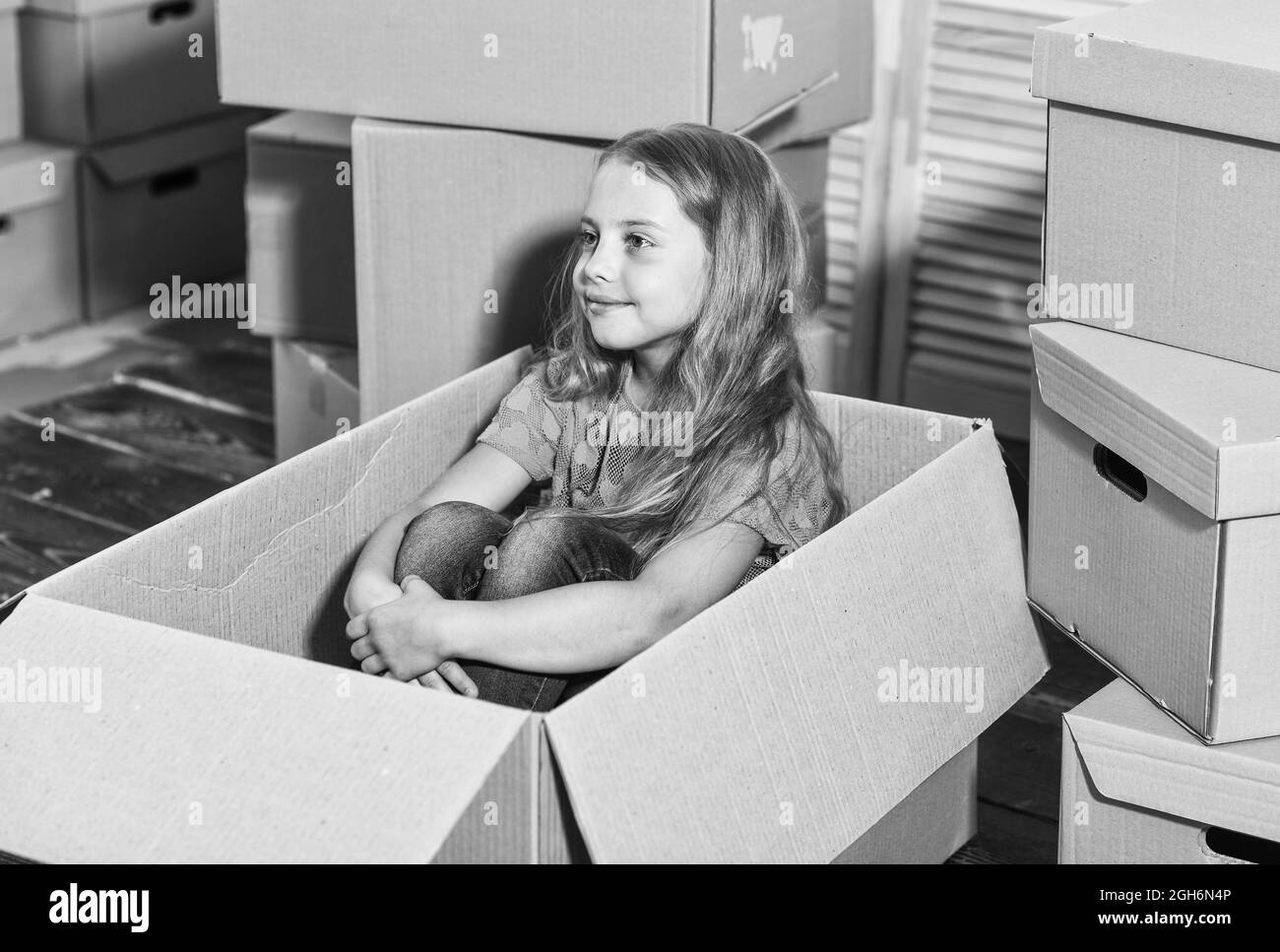 Appartamento per famiglie. Entusiasta della nuova casa. Scatola da gioco per bambini. Concetto di uscita. Preparatevi per lo spostamento. Uscire. Imballaggio degli oggetti. Casa dolce Foto Stock