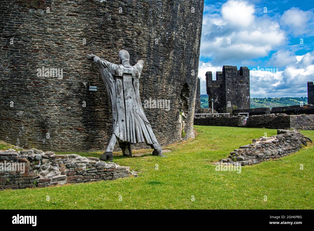 Figura modello 'tenendo in su' la torre pendente del castello di Caerphilly. Galles. REGNO UNITO Foto Stock