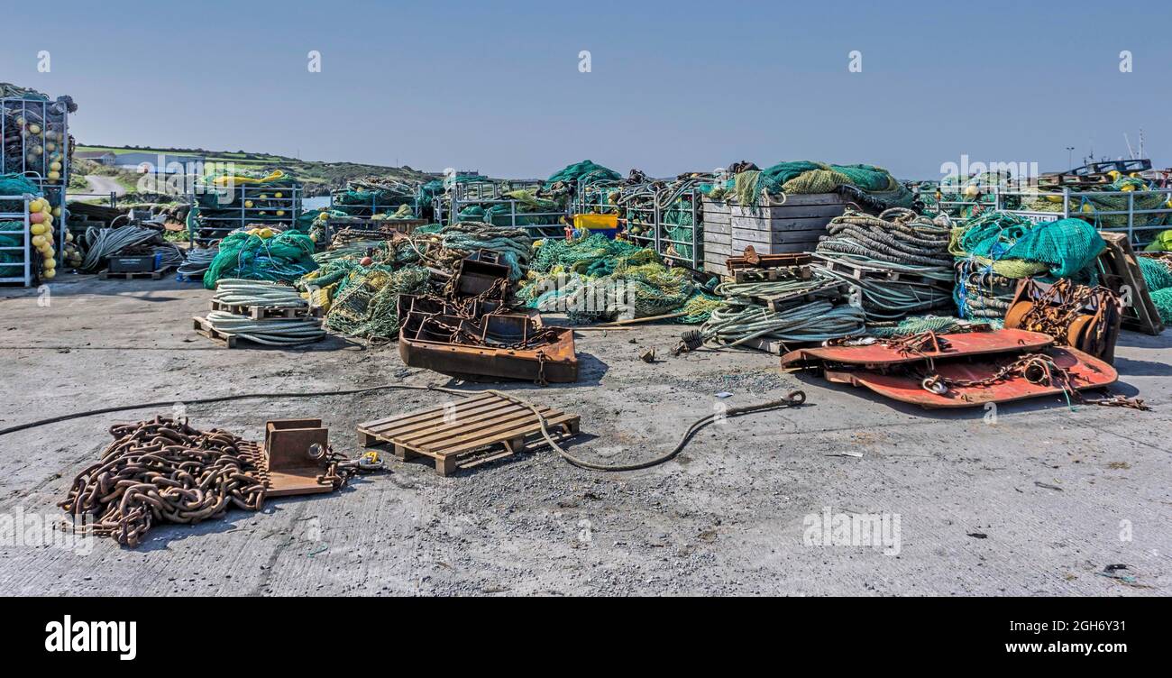 Fasci di reti da pesca e attrezzature da pesca sul molo nel villaggio di pescatori di Clogherhead, County Louth, Irlanda. Foto Stock
