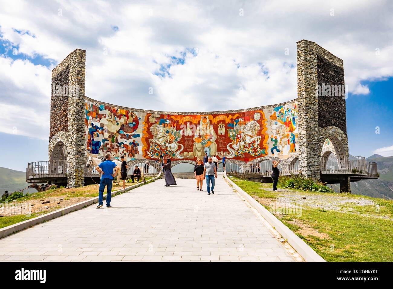Gudauri, Georgia - 11 luglio 2021: Punto di vista Gudauri punto panoramico sulla cima della montagna con viste mozzafiato sul dipinto e concreto monumento dell'amicizia Russia-Georgia Foto Stock