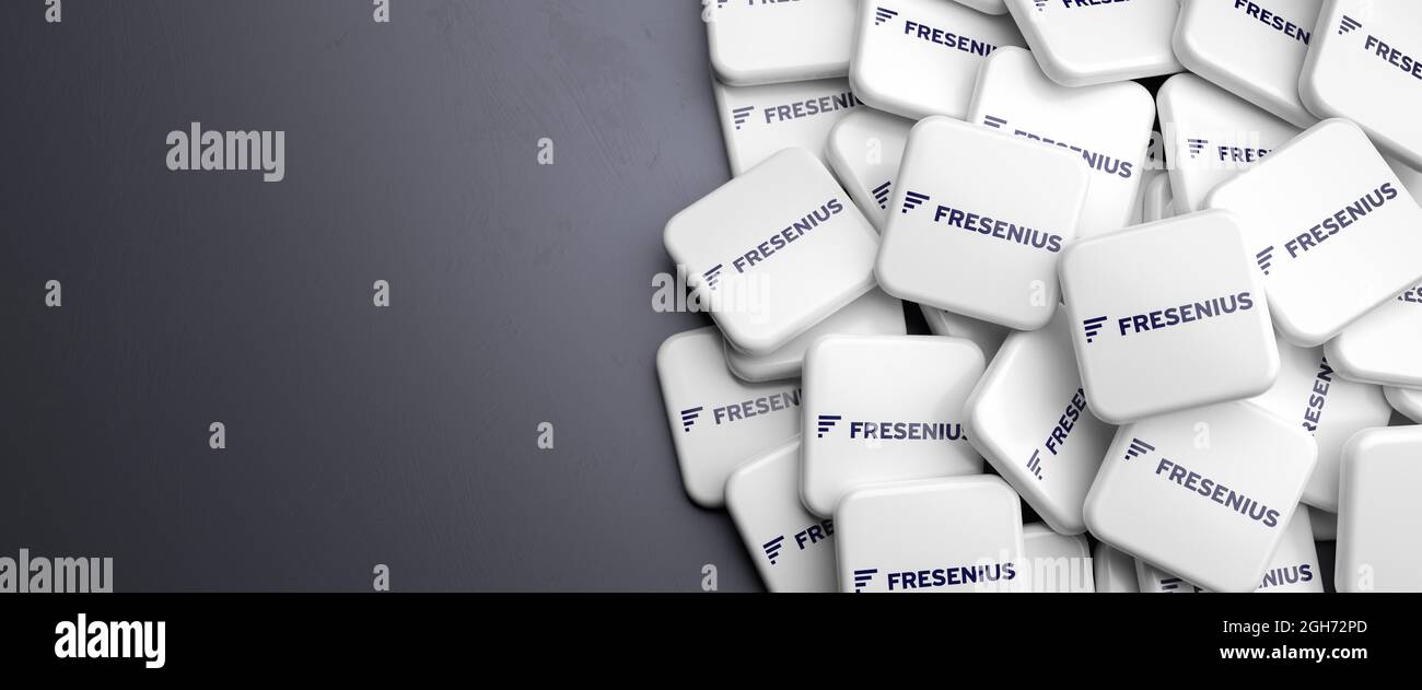 Loghi della società tedesca di assistenza sanitaria Fresenius su un mucchio su un tavolo. Spazio di copia. Formato banner Web. Foto Stock