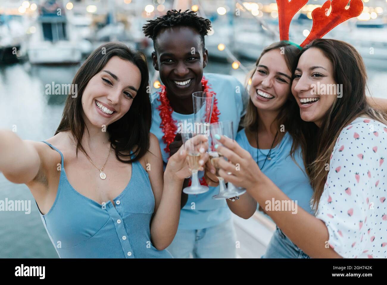 Felice persone diverse divertirsi e prendere selfie durante la celebrazione di nuovo anno Foto Stock