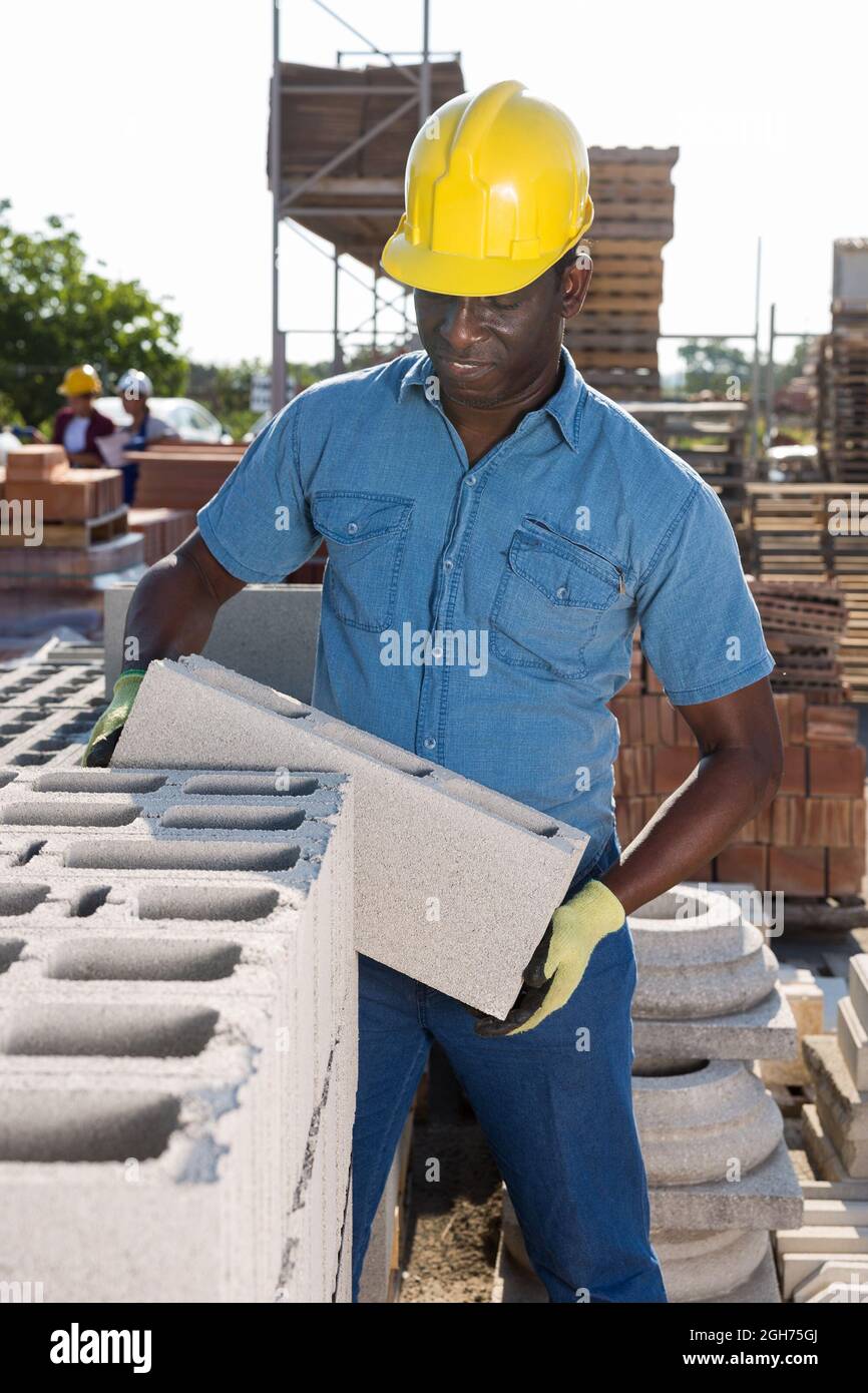 Il magazzino dei lavoratori afroamericani depone mattoni Foto Stock