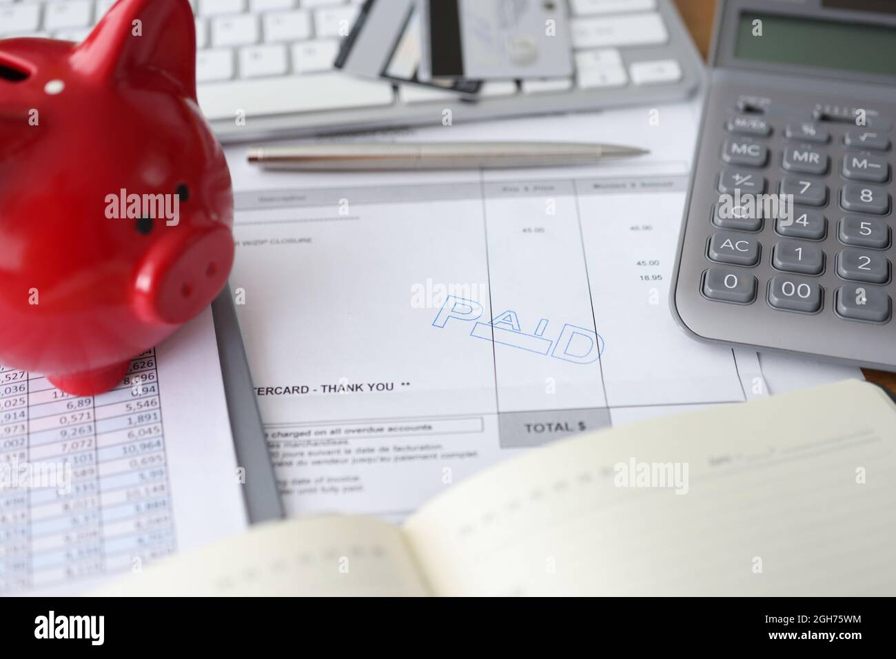 Fattura pagamento conto finanziario pagato e Piggy banca Piggy su tavola Foto Stock