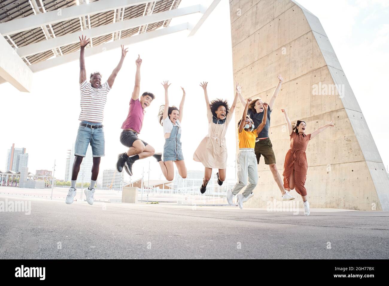 Gruppo di amici multietnici felici divertirsi. Giovani studenti che saltano fuori dall'università. Foto Stock