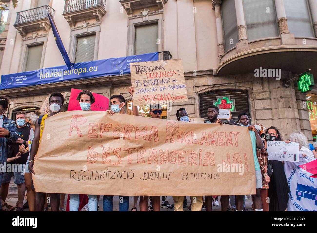 I manifestanti tengono una bandiera e dei cartelli durante la dimostrazione. Circa trenta persone hanno dimostrato di fronte alla sede dell'Unione europea a Barcellona e si sono poi trasferite alla delegazione del governo spagnolo in Catalogna per chiedere l'accesso ai diritti dei giovani migranti sotto la tutela e la riforma del regolamento della legge sugli stranieri. Il governo dello Stato spagnolo, più di un anno fa, ha promesso di riformare il regolamento sull'immigrazione, ma non ha ancora annunciato alcuna riforma. (Foto di Thiago Prudencio/SOPA Images/Sipa USA) Foto Stock