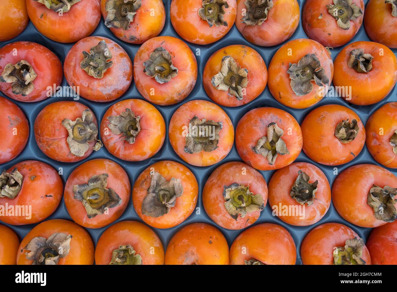 Delizioso primo piano di frutti di persimmon maturi sulla bancarella del mercato Foto Stock