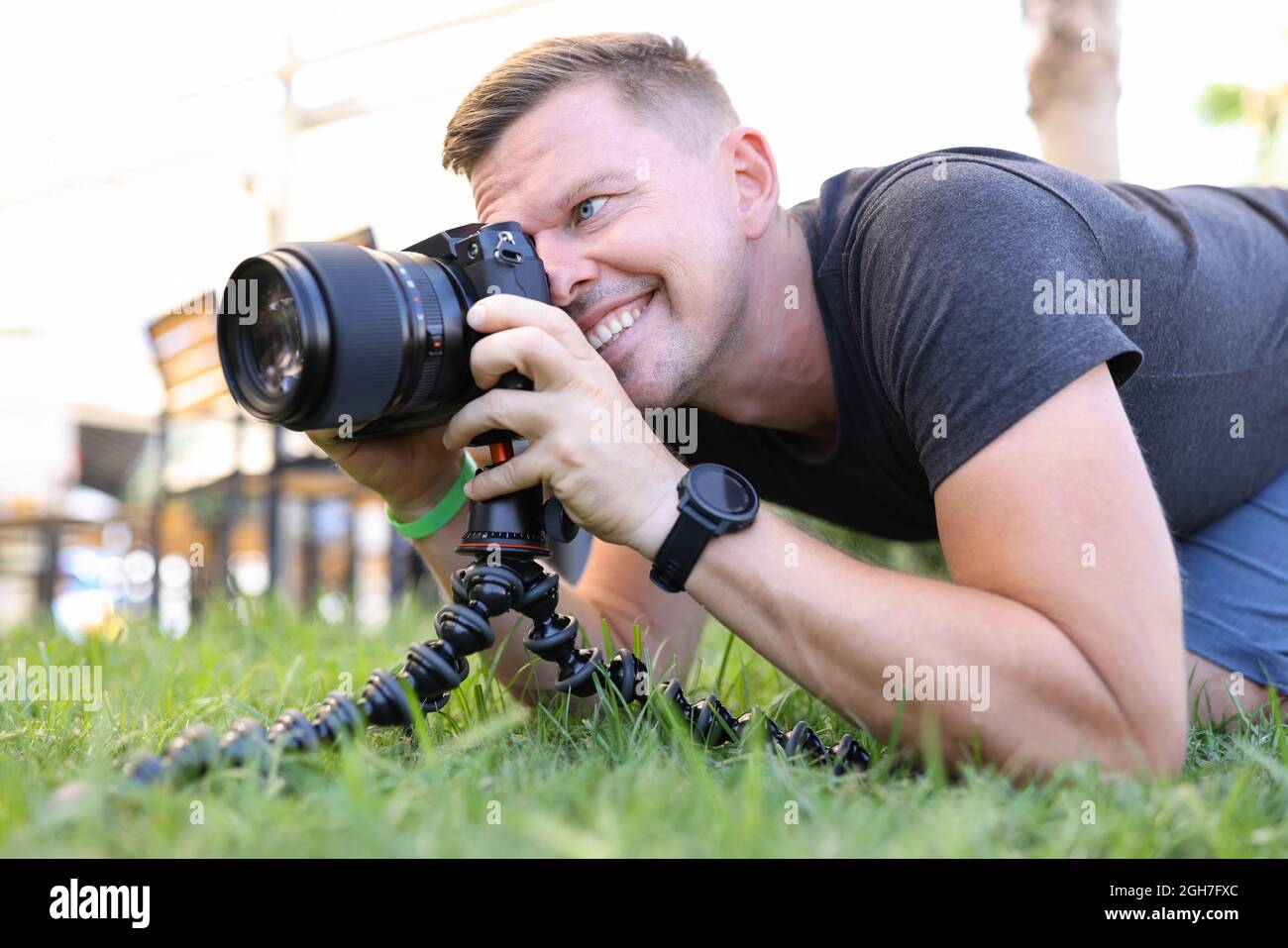 Giovane fotografo maschile scatta foto su treppiede in primo piano Foto Stock