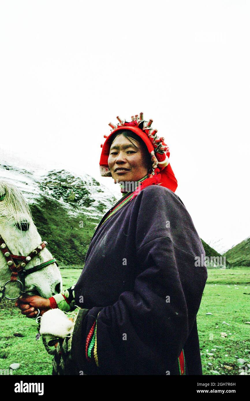 Una donna tibetana con il suo cavallo nella regione del Tagong Grassland del Tibet orientale (provincia occidentale del Sichuan), in Cina. Foto Stock