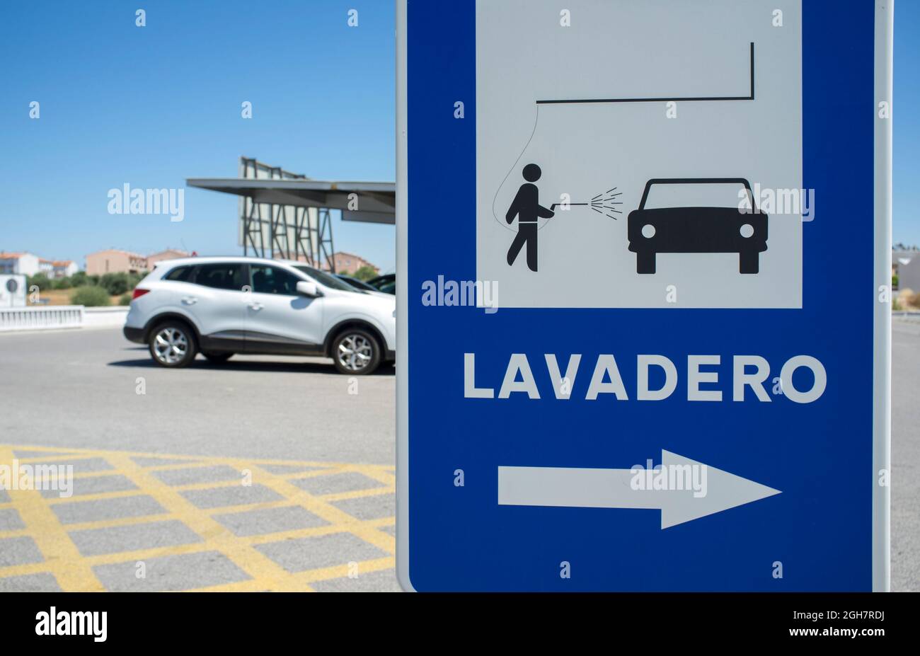 Cartello area lavaggio auto. Veicolo utilitario sportivo in background. Lingua spagnola Foto Stock