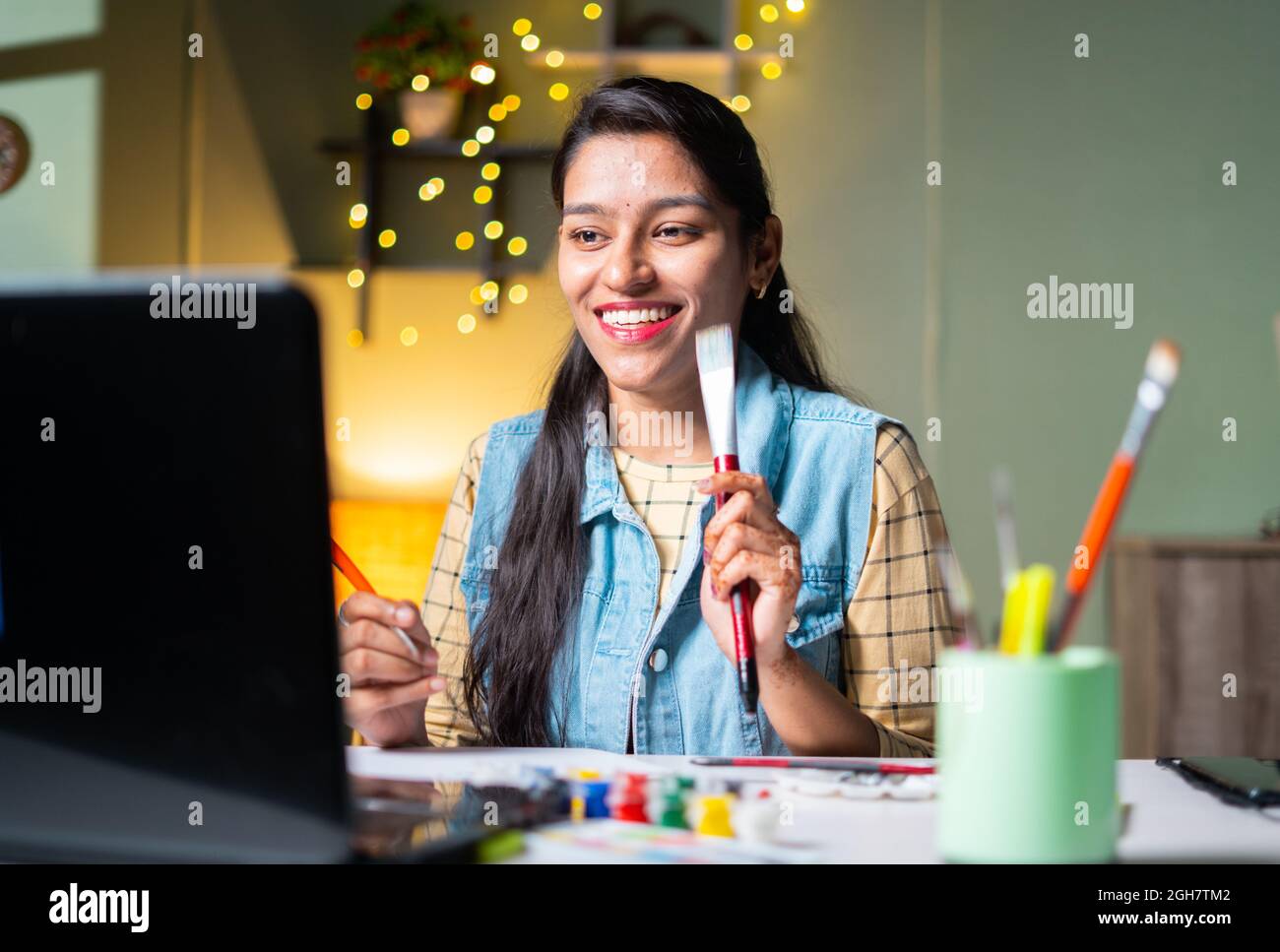 Giovane ragazza Indain imparare pittura da classe online guardando in laptop - concetto di formazione virtuale online, videochiamata, internet e. Foto Stock