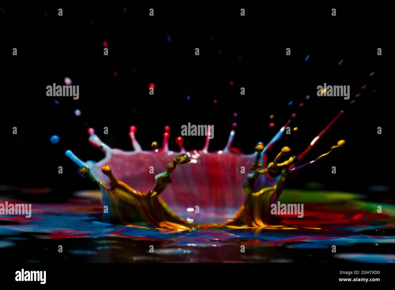 Foto flash ad alta velocità di una goccia di liquido colorata. La gocciolina viene a cadere nel liquido e produce una corona multicolore. Foto Stock