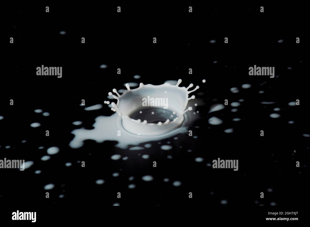 Flash ad alta velocità per fotografare le gocce di latte. La gocciolina si atterra nel liquido e produce una coronetta. Foto Stock