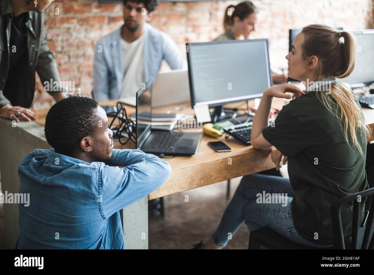 Programmatori maschi e femmine che codificano su computer in ufficio Foto Stock
