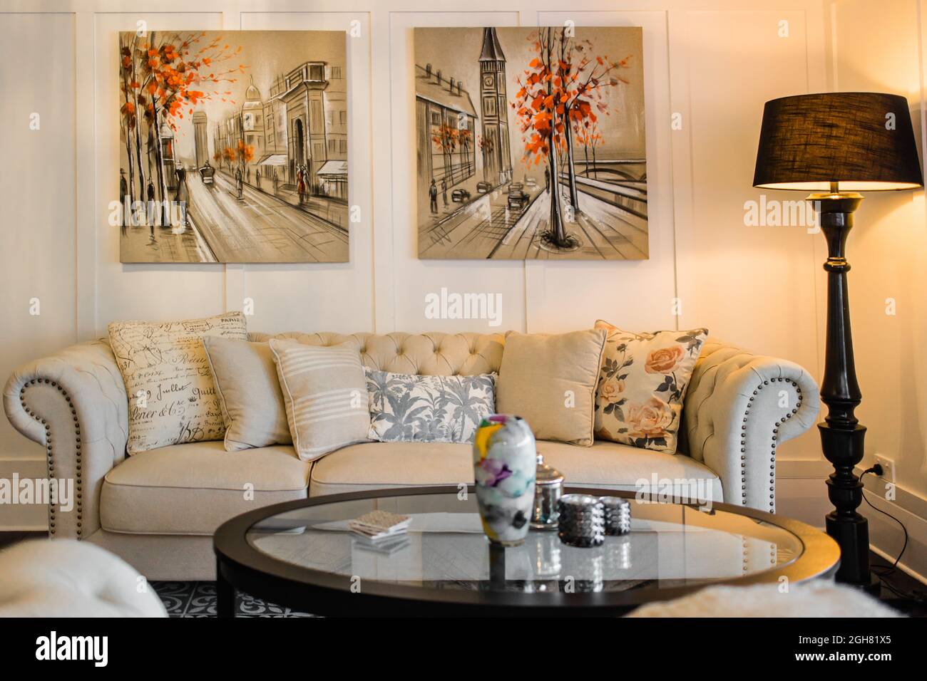 Ampio e confortevole soggiorno con divano luminoso e dipinti alle pareti Foto Stock