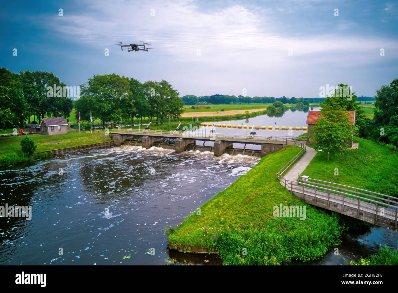 L'acqua scorre dal wir nel fiume Vecht nei Paesi Bassi. A valle, Lock Keeper's House accanto al ponte. Passaggio dei pesci, scala dei pesci al Foto Stock