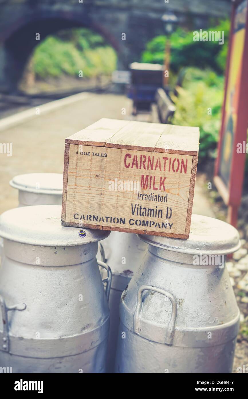 Vintage gabbia di legno di Carnation forniture di latte in attesa di trasporto su ferrovia a vapore patrimonio, rievocazione del 1940s, WW2 periodo di guerra. Foto Stock