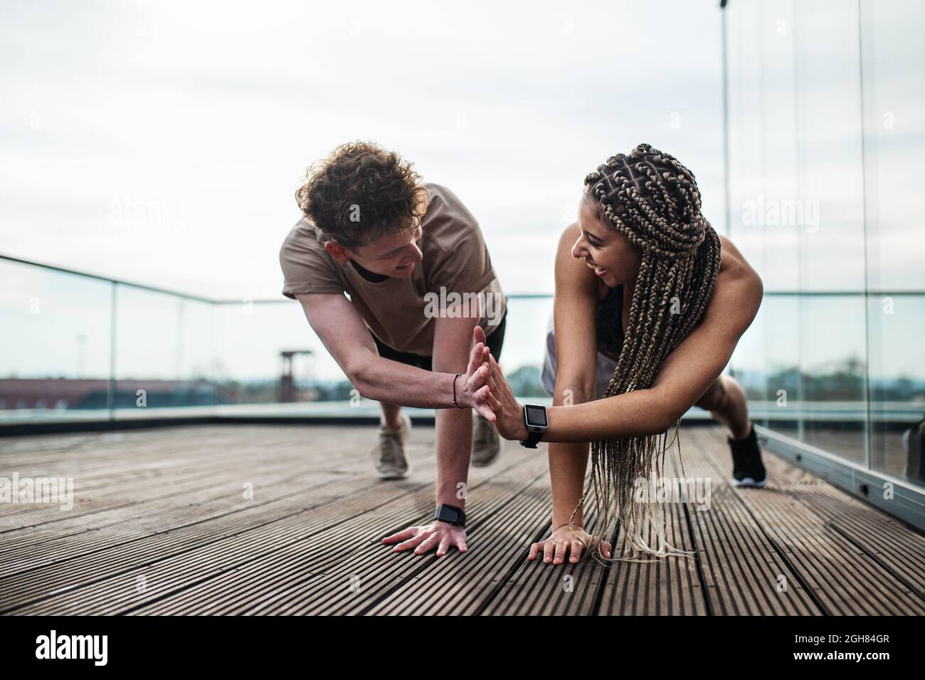 Giovane coppia che fa esercizio all'aperto sulla terrazza, sport e stile di vita sano concetto. Foto Stock