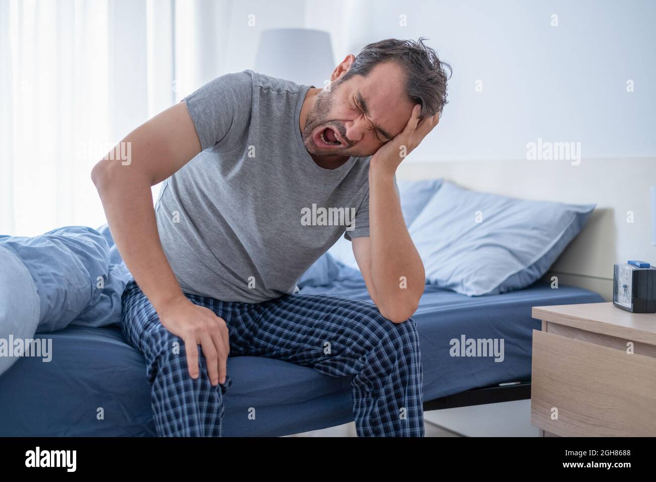 Uomo stanco che si svegliò presto la mattina Foto stock - Alamy